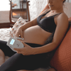 Photo of pregnant person using the BabyHeart Standard doppler in the comfort of her home